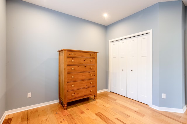 bedroom with light hardwood / wood-style floors and a closet