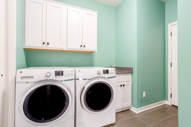 laundry room with separate washer and dryer, dark tile patterned flooring, sink, and cabinets