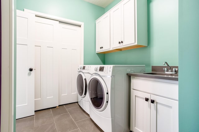 washroom featuring sink, independent washer and dryer, light tile patterned floors, and cabinets