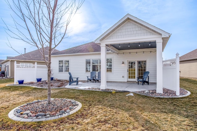 rear view of house with a patio area and a lawn