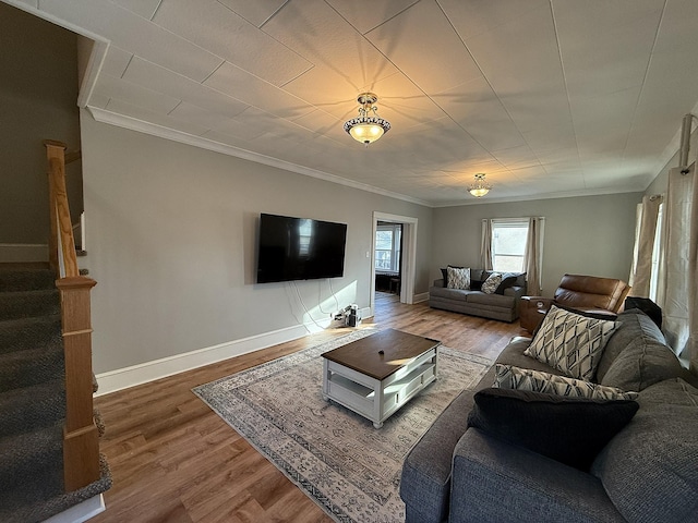 living room with ornamental molding, wood finished floors, baseboards, and stairs