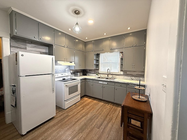 kitchen featuring under cabinet range hood, white appliances, a sink, gray cabinets, and open shelves