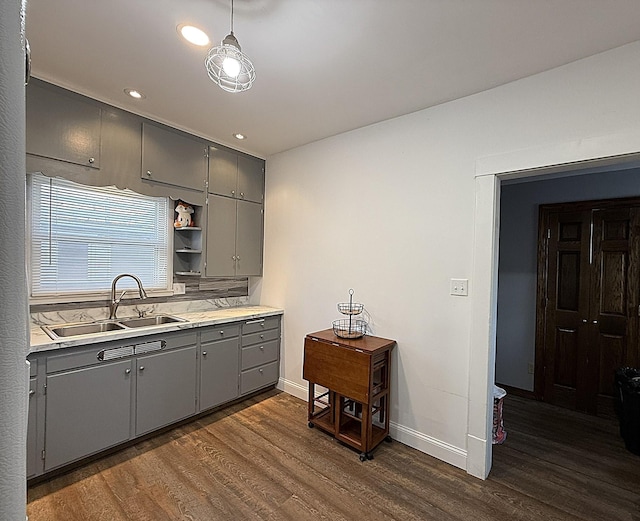 kitchen with gray cabinetry, a sink, light countertops, open shelves, and dark wood finished floors