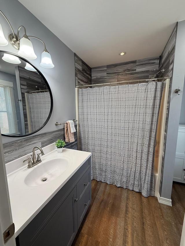 full bathroom featuring shower / bath combo with shower curtain, wood finished floors, and vanity