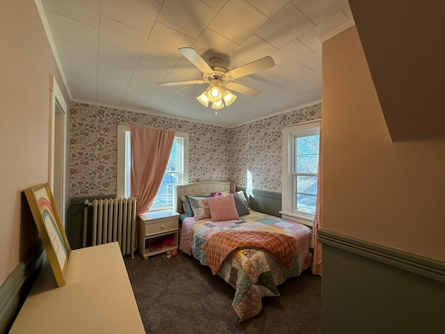 bedroom with ceiling fan, carpet floors, wallpapered walls, radiator heating unit, and crown molding