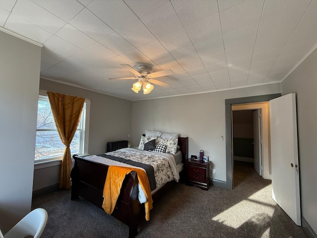 bedroom with carpet flooring, a ceiling fan, baseboards, radiator, and crown molding