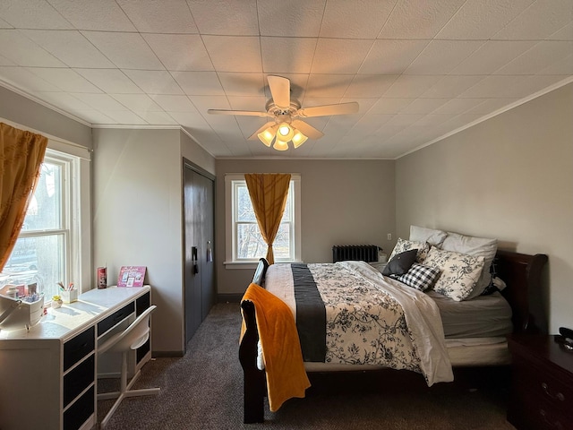 carpeted bedroom with ornamental molding, radiator heating unit, and a ceiling fan