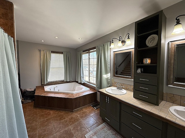 full bathroom with a garden tub, double vanity, backsplash, and a sink