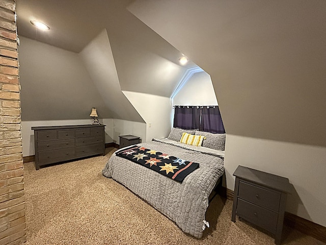 carpeted bedroom with lofted ceiling and baseboards