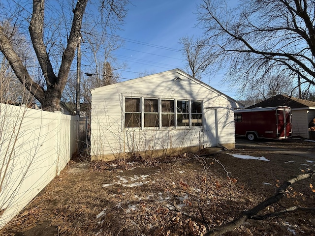 view of side of home featuring fence