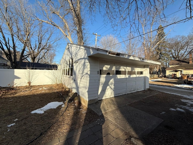 view of side of property with a garage and fence