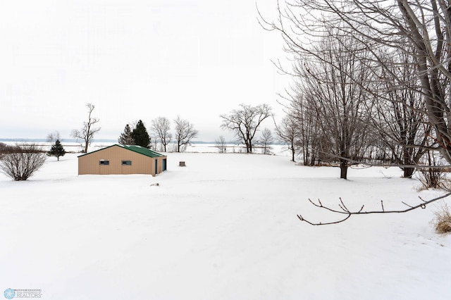 yard covered in snow featuring an outbuilding