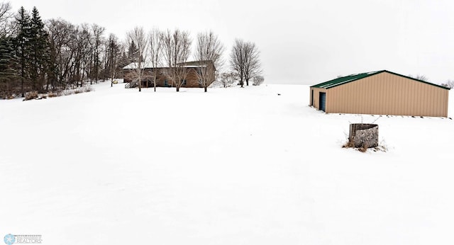 snowy yard featuring an outbuilding