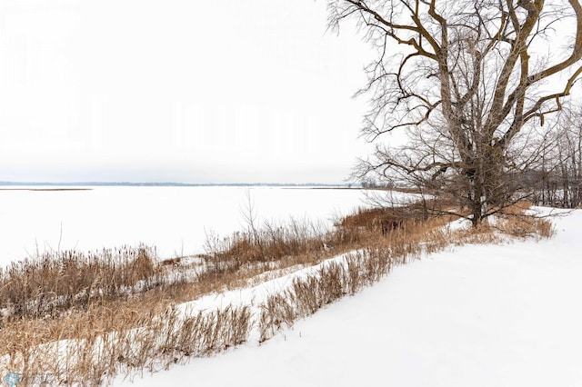 snowy yard featuring a water view