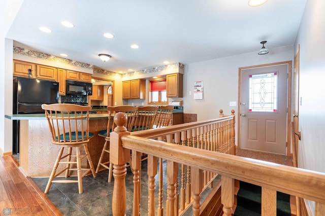 kitchen featuring black appliances, a kitchen breakfast bar, and kitchen peninsula