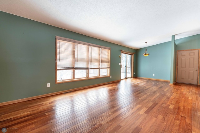 empty room with a textured ceiling and hardwood / wood-style flooring