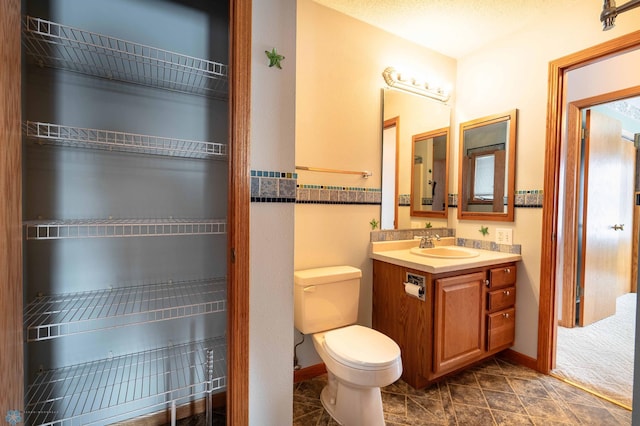 bathroom featuring tile patterned floors, vanity, and toilet