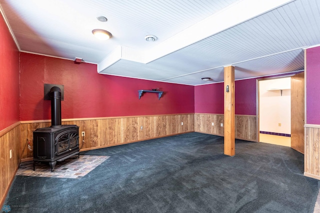 unfurnished living room with dark colored carpet and a wood stove