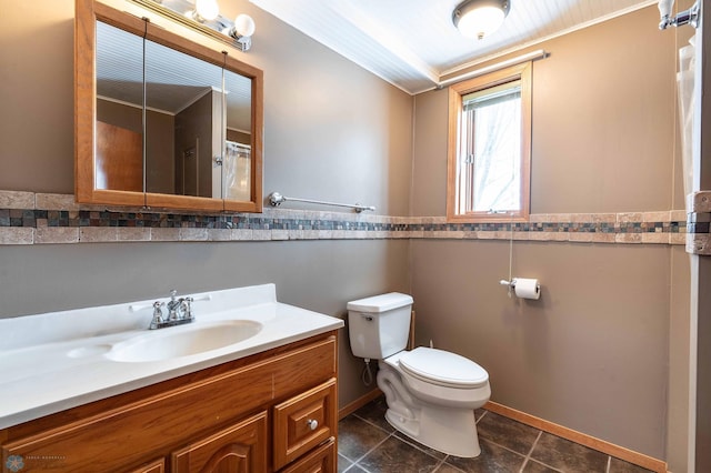 bathroom with tile patterned flooring, vanity, toilet, and ornamental molding