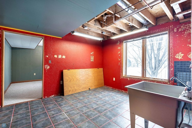 interior space featuring dark colored carpet, sink, and a wealth of natural light