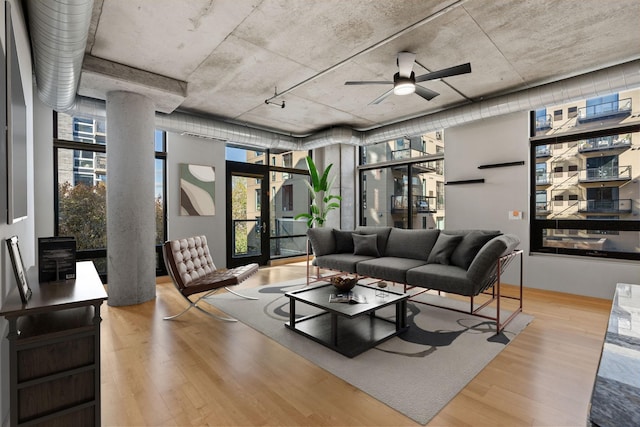 living room featuring ceiling fan, light hardwood / wood-style flooring, and expansive windows