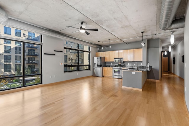 kitchen featuring hanging light fixtures, ceiling fan, light wood-type flooring, light brown cabinetry, and appliances with stainless steel finishes