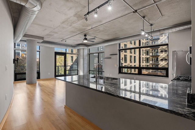 hall with french doors, light wood-type flooring, and sink