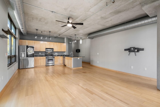 kitchen with pendant lighting, light hardwood / wood-style flooring, light brown cabinetry, appliances with stainless steel finishes, and kitchen peninsula