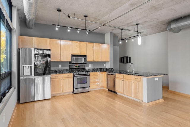 kitchen featuring kitchen peninsula, light brown cabinets, and stainless steel appliances