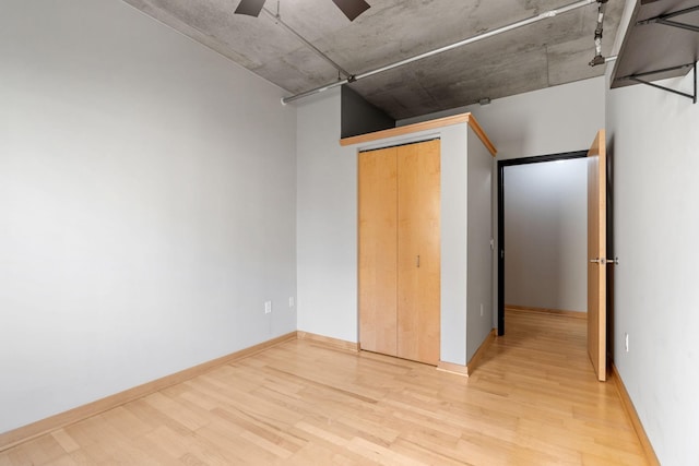 unfurnished bedroom with a closet, light hardwood / wood-style flooring, and ceiling fan