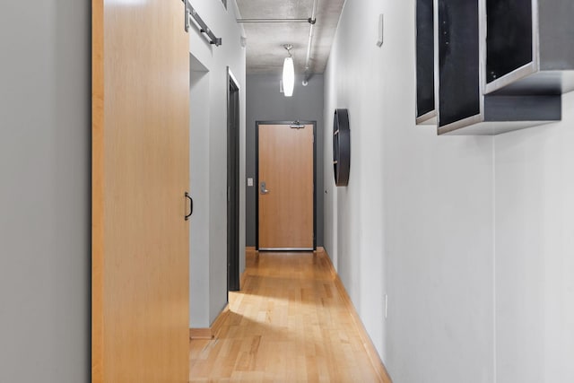 hallway featuring a barn door and hardwood / wood-style flooring