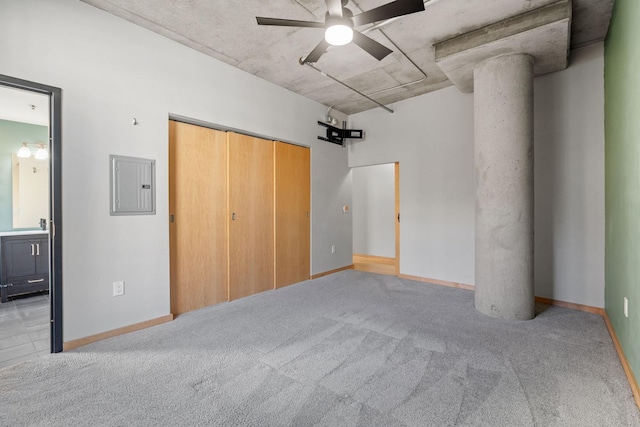 unfurnished bedroom featuring electric panel, ceiling fan, a closet, and light colored carpet