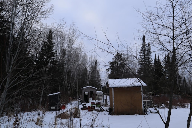 snowy yard with a shed