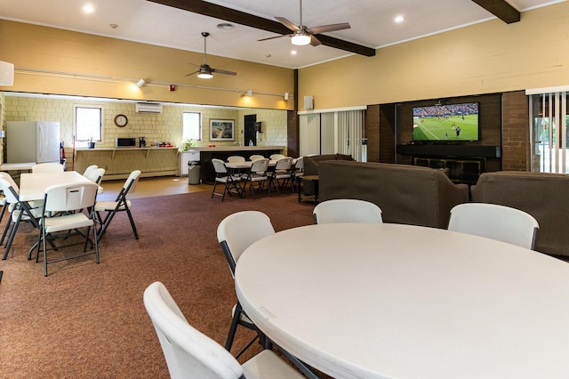 dining space with a fireplace, beam ceiling, and ceiling fan