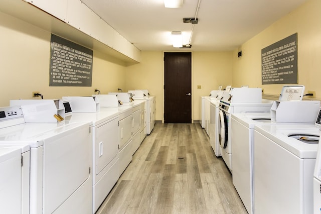 laundry room featuring separate washer and dryer and light wood-type flooring