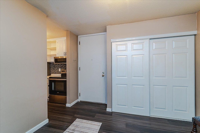 bedroom with dark hardwood / wood-style flooring, a textured ceiling, and a closet