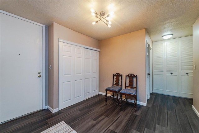 entrance foyer with a chandelier, a textured ceiling, and dark hardwood / wood-style floors