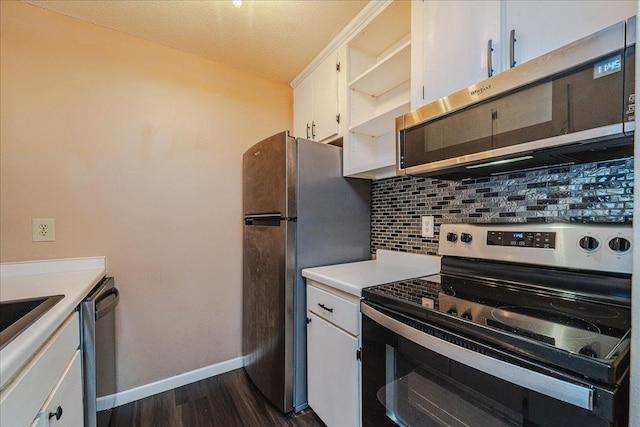 kitchen with appliances with stainless steel finishes, tasteful backsplash, a textured ceiling, white cabinets, and dark hardwood / wood-style floors