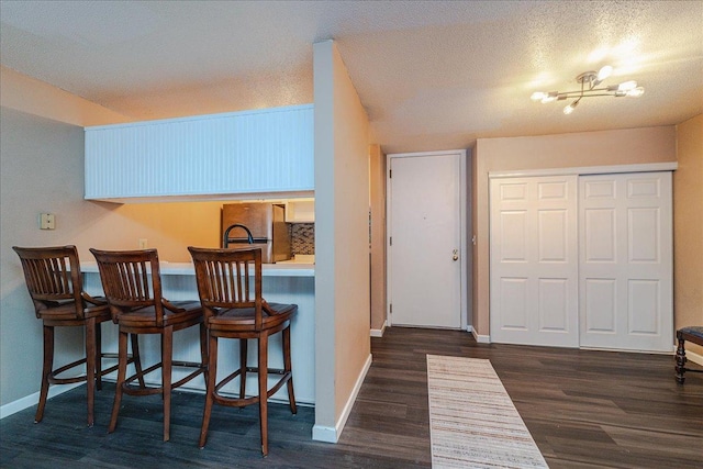 2800 Hamline Ave N Unit 150, Roseville, MN 55113 - kitchen featuring wood finished floors, a kitchen breakfast bar, freestanding refrigerator, and baseboards