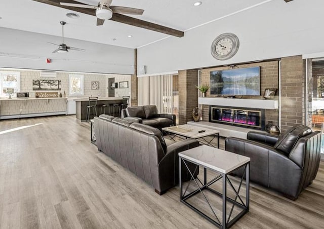 2800 Hamline Ave N Unit 150, Roseville, MN 55113 - living area with ceiling fan, light wood-type flooring, brick wall, beamed ceiling, and a glass covered fireplace
