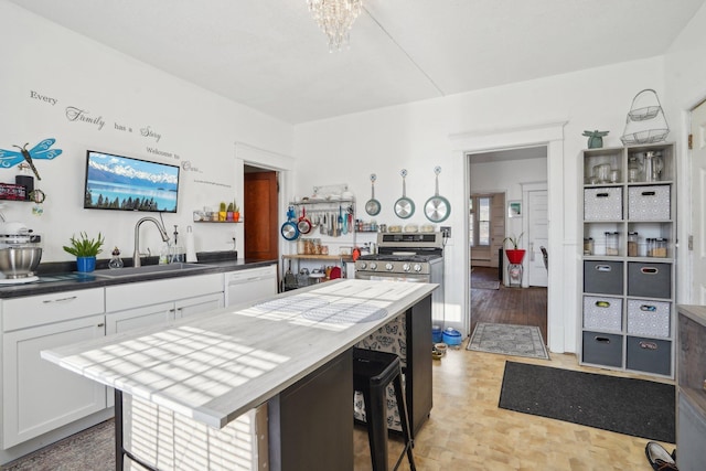 kitchen with white dishwasher, white cabinetry, sink, a kitchen island, and a breakfast bar