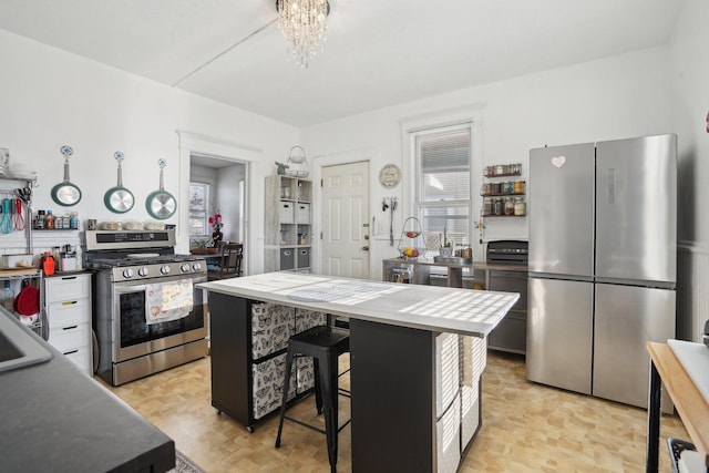 kitchen with a kitchen breakfast bar, an inviting chandelier, a center island, and stainless steel appliances