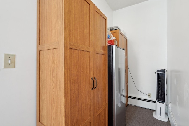 details with a baseboard radiator and stainless steel fridge