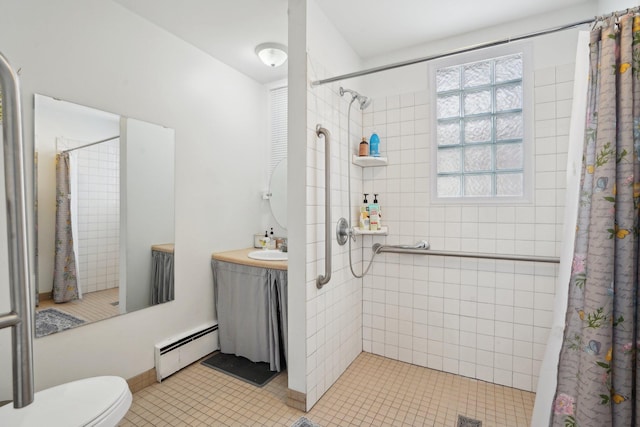 bathroom featuring toilet, curtained shower, a baseboard heating unit, tile patterned flooring, and sink