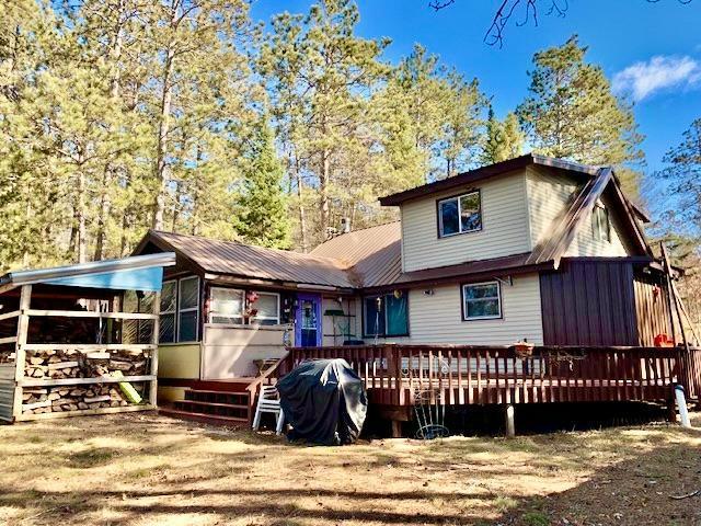 back of house featuring a sunroom and a wooden deck