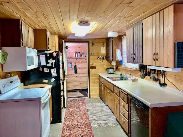 kitchen featuring wood walls, white appliances, sink, and wooden ceiling