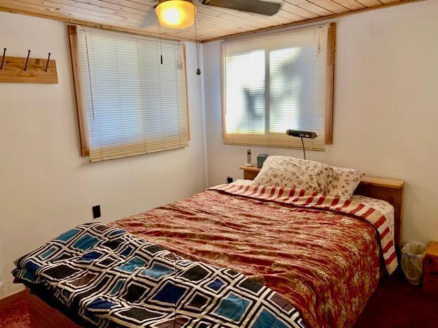 bedroom with ceiling fan and wood ceiling