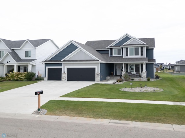 craftsman-style house featuring covered porch, a garage, and a front lawn