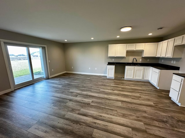 kitchen featuring hardwood / wood-style flooring, sink, and white cabinets