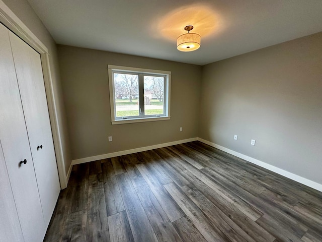 unfurnished bedroom featuring dark wood-type flooring and a closet